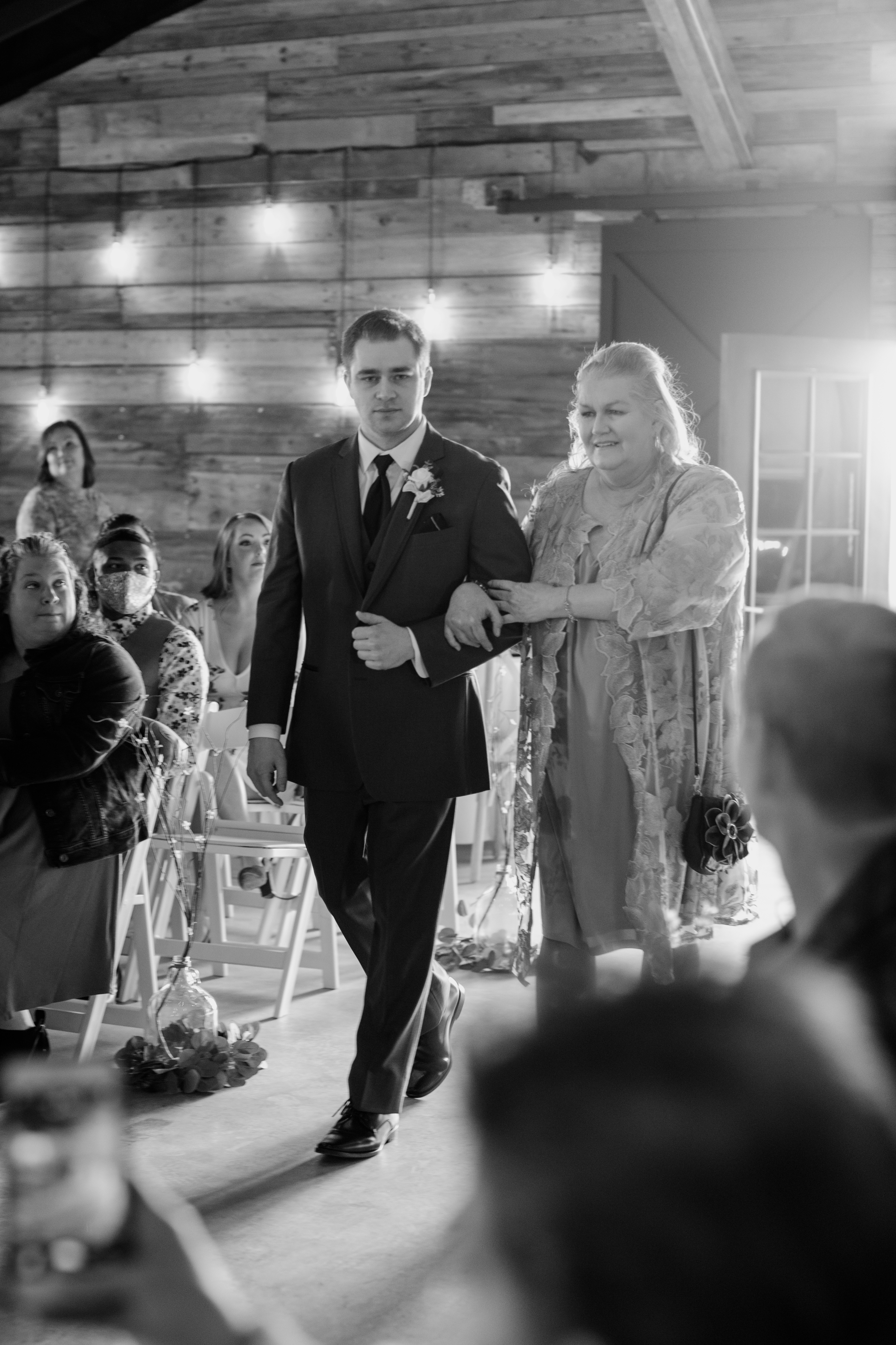 groom walking down aisle with mother
